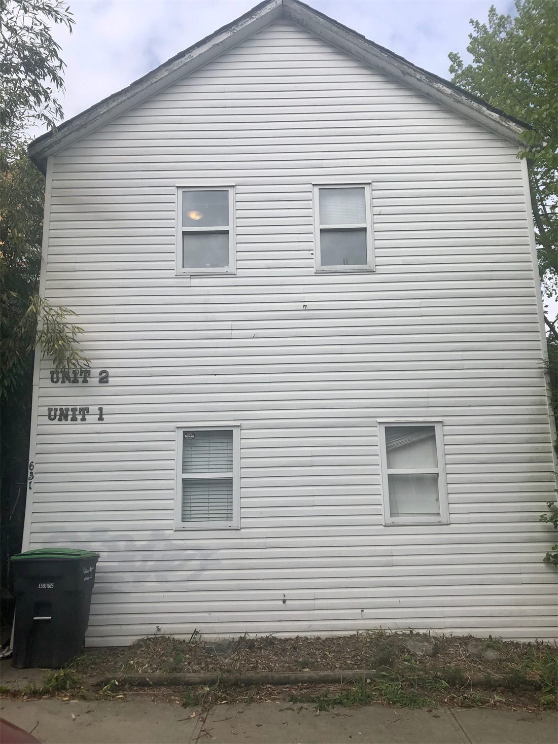 The blank side wall of 631 Cordova, two small windows and no porch or front door onto the street